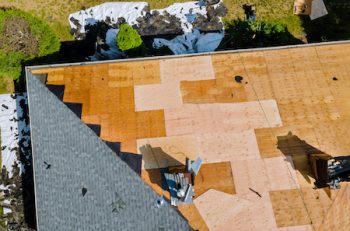 A Roofer Nailing Shingles With Air Gun, Replacing Roof Cover Protection Being Applied