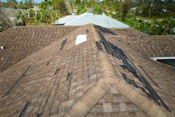 Damaged House Roof With Missing Shingles After Hurricane Ian In Florida. Consequences Of Natural Disaster